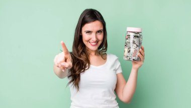 Genç ve güzel bir kadın gururla gülümsüyor ve kendinden emin bir numara oluyor. kaydetme kavramı