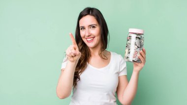 Genç, güzel bir bayan gülümsüyor ve arkadaş canlısı görünüyor. Bir numarayı gösteriyor. kaydetme kavramı