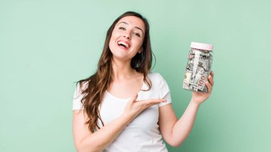 Genç, güzel bir kadın neşeyle gülümsüyor, mutlu hissediyor ve bir konsept gösteriyor. kaydetme kavramı