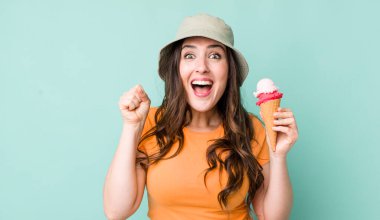 young pretty woman  feeling shocked,laughing and celebrating success. summer and ice cream concept