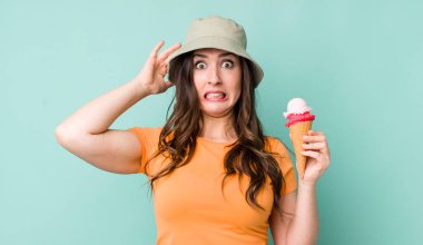 young pretty woman  feeling stressed, anxious or scared, with hands on head. summer and ice cream concept