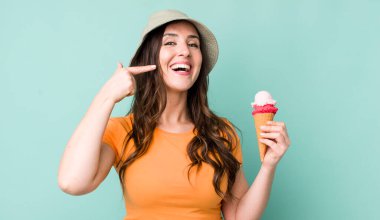 young pretty woman  smiling confidently pointing to own broad smile. summer and ice cream concept