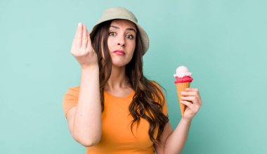 young pretty woman  making capice or money gesture, telling you to pay. summer and ice cream concept