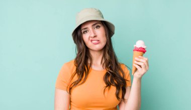 young pretty woman  looking puzzled and confused. summer and ice cream concept