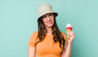 young pretty woman  feeling puzzled and confused. summer and ice cream concept