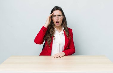 Genç ve güzel bir kadın mutlu, şaşkın ve şaşırmış görünüyor. iş kavramı