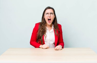 Genç ve güzel bir kadın agresif bir şekilde bağırıyor, çok kızgın görünüyor. iş kavramı