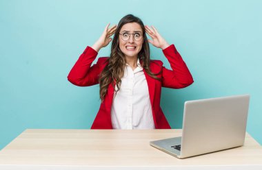 young pretty woman  feeling stressed, anxious or scared, with hands on head. business desk concept