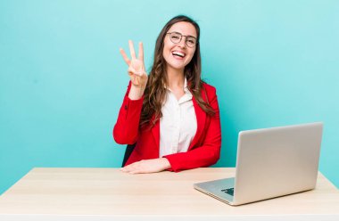 young pretty woman  smiling and looking friendly, showing number three. business desk concept
