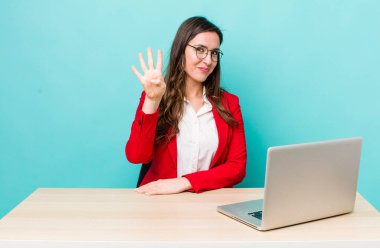 young pretty woman  smiling and looking friendly, showing number four. business desk concept