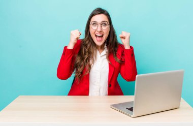 young pretty woman  shouting aggressively with an angry expression. business desk concept