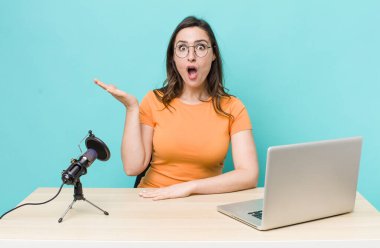young pretty woman  looking surprised and shocked, with jaw dropped holding an object. influencer concept