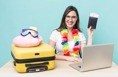 young pretty woman  smiling happily with a hand on hip and confident. summer travel concept