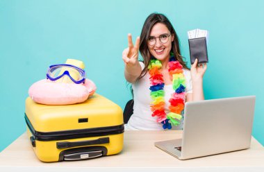 young pretty woman  smiling and looking happy, gesturing victory or peace. summer travel concept