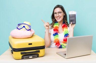 young pretty woman  smiling cheerfully, feeling happy and pointing to the side. summer travel concept