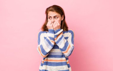 Genç, güzel bir kadın endişeli, gergin, stresli ve korkmuş görünüyor. Tırnaklarını yiyor ve yanal fotokopi için yer arıyor.