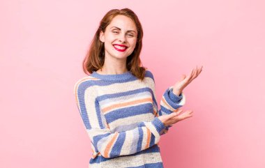 Genç ve güzel bir kadın gururla ve güvenle gülümsüyor, mutlu ve tatmin olmuş hissediyor ve fotokopi alanında bir konsept gösteriyor.