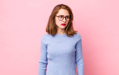 Genç, güzel bir kadın üzgün, üzgün ya da kızgın ve olumsuz bir tavır takınıyor, anlaşmazlık içinde kaşlarını çatıyor.