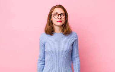 Genç ve güzel bir kadın kafası karışmış görünüyor, merak ediyor veya bir sorunu çözmeye çalışıyor ya da düşünüyor.