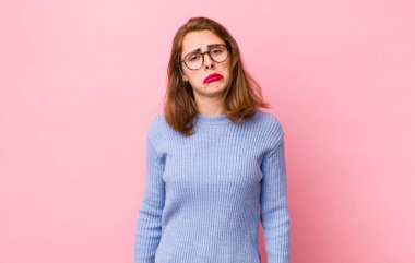 Genç ve güzel bir kadın üzgün ve mızmızlanıyor, mutsuz bir bakışla, negatif ve hayal kırıklığına uğramış bir tavırla ağlıyor.