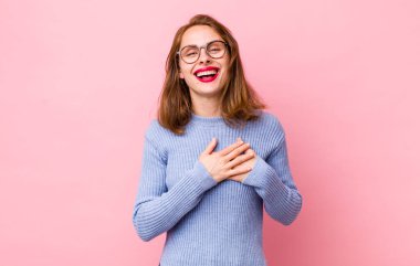 Genç, güzel bir kadın romantik, mutlu ve aşık, neşeyle gülümseyen ve kalbe yakın el ele tutuşan