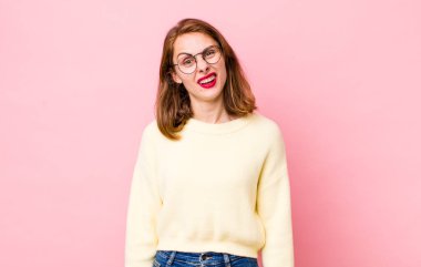 Genç, güzel bir kadın şaşkın ve şaşkın hissediyor, aptal, sersemlemiş bir ifadeyle beklenmedik bir şeye bakıyor.