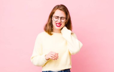 Genç ve güzel bir kadın stresli, hayal kırıklığına uğramış ve yorgun, endişeli ve sorunlu bir bakışla boynunu ovalıyor.