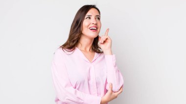 Genç ve güzel bir kadın mutlu bir şekilde gülümsüyor ve yan bakıyor, merak ediyor, düşünüyor ya da bir fikri var.