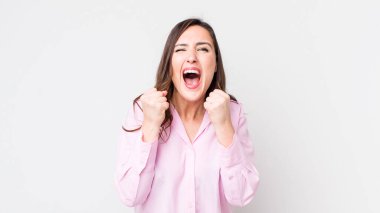 Genç, güzel bir kadın sinirli, sinirli, kızgın bakışlar ve sıkı yumruklar ile agresif bir şekilde bağırıyor.