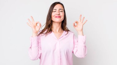 Genç ve güzel bir kadın konsantre olmuş ve meditasyon yapıyor, tatmin olmuş ve rahatlamış hissediyor, düşünüyor ya da bir seçim yapıyor.