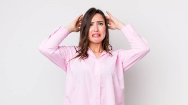 Genç, güzel bir kadın kendini stresli, endişeli, endişeli ya da korkmuş hissediyor. Elleri başının üstünde, hatayla panikliyor.