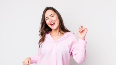 Genç, güzel bir kadın gülümsüyor, kaygısız hissediyor, rahat ve mutlu, dans ediyor ve müzik dinliyor, bir partide eğleniyor.