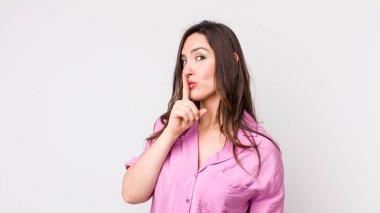 Genç ve güzel bir kadın sessizlik ve sessizlik istiyor, parmaklarıyla ağzının önünde işaret ediyor, 