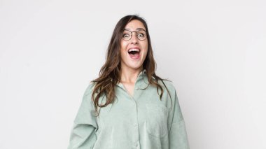 Genç ve güzel bir kadın mutlu ve hoş bir şekilde şaşırmış görünüyor. Büyülenmiş ve şok olmuş bir ifadeyle heyecanlanıyor.