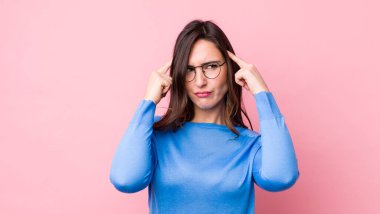 Genç ve güzel bir kadın kafası karışık ya da şüpheci, bir fikre odaklanmış, çok düşünüyor, kenarda boşluğu kopyalamak istiyor.