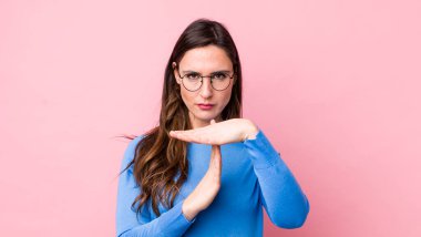 Genç ve güzel bir kadın ciddi, sert, kızgın ve hoşnutsuz görünüyor.