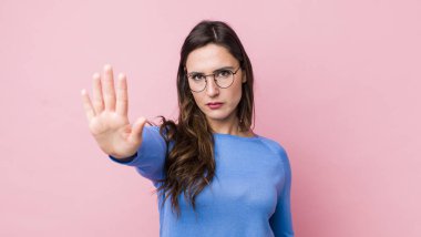 Genç ve güzel bir kadın ciddi, sert, hoşnutsuz ve kızgın görünüyor.