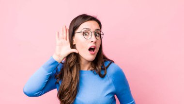 Genç, güzel bir kadın gülümsüyor, tuhaf bir şekilde yan tarafa bakıyor, dedikoduları dinlemeye ya da bir sırrı duymaya çalışıyor.