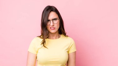 Genç, güzel bir kadın üzgün, üzgün ya da kızgın ve olumsuz bir tavır takınıyor, anlaşmazlık içinde kaşlarını çatıyor.