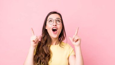 Şok olmuş, şaşırmış ve ağzı açık genç bir kadın. İki elini de havaya kaldırıp boşluğu dolduruyor.