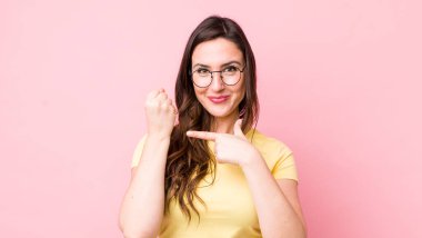 Genç ve güzel bir kadın sabırsız ve kızgın görünüyor, saati gösteriyor, dakiklik istiyor, zamanında gelmek istiyor.