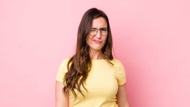 Genç ve güzel bir kadın mutlu ve arkadaş canlısı görünüyor, gülümsüyor ve sana olumlu bir tavırla göz kırpıyor.