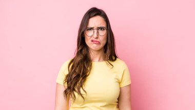 Genç ve güzel bir kadın üzgün ve mızmızlanıyor, mutsuz bir bakışla, negatif ve hayal kırıklığına uğramış bir tavırla ağlıyor.