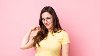 Genç, güzel bir kadın neşeli ve kendinden emin bir şekilde gülüyor. Sıradan, mutlu, dostane bir gülümsemeyle.