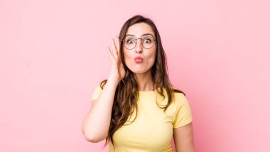 Genç, güzel bir kadın, ağzı açık bir şekilde yüz yüze inanmayarak şok olmuş ve hayrete düşmüş hissediyor.