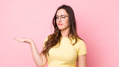 Genç, güzel bir kadın kendini mutlu hissediyor ve gülümsüyor. Yan taraftaki bir nesneye ya da konsepte bakıyor.