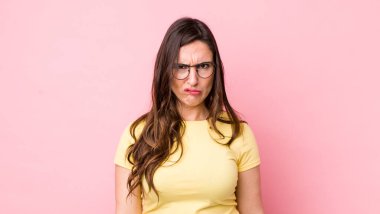 Genç ve güzel bir kadın kafası karışık ve kuşkulu, merak ediyor ya da karar vermeye çalışıyor.