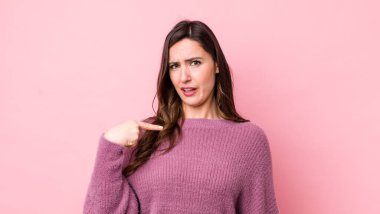 Kafası karışmış, kafası karışmış ve kendine güveni olmayan genç bir kadın kendini göstererek kim olduğunu soruyor, ben mi??