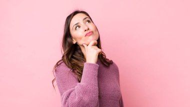 Genç, güzel bir kadın düşünceli, meraklı ya da hayal kuruyor, hayal kuruyor ve gökyüzüne bakıyor.