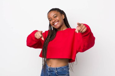 afro pretty woman feeling happy and confident, pointing to camera with both hands and laughing, choosing you